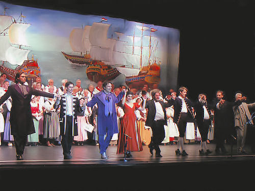 Die Hauptdarsteller sowie Walter Langenfeld und weitere Personen verbeugen sich vor dem applaudierenden Publikum Foto